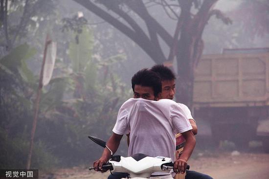 ▲印尼坤甸，民众在雾霾天气中出行。|视觉中国