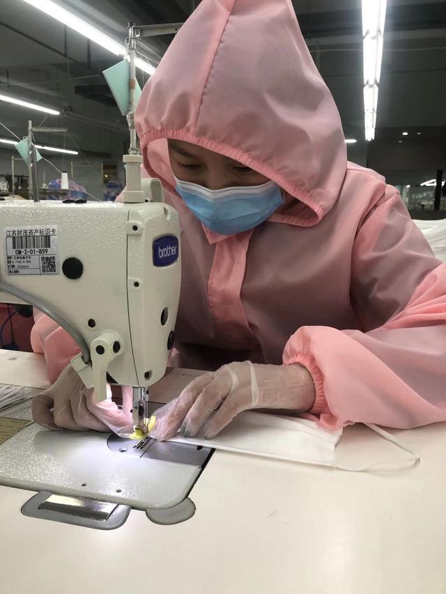 图为淘帝一线工人用针车手工缝制口罩。