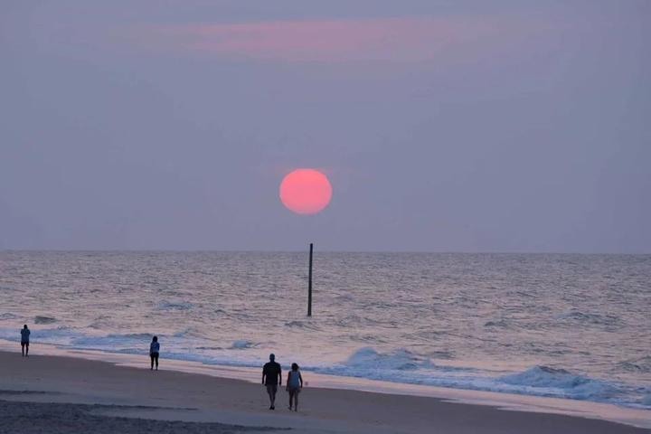 People walking along the beach at sunset on Ocracoke