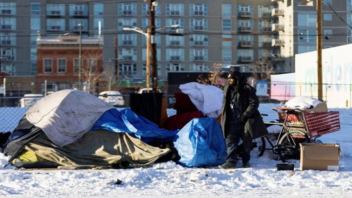 [file photo] A man stands outside of his tent during a period of cold weather