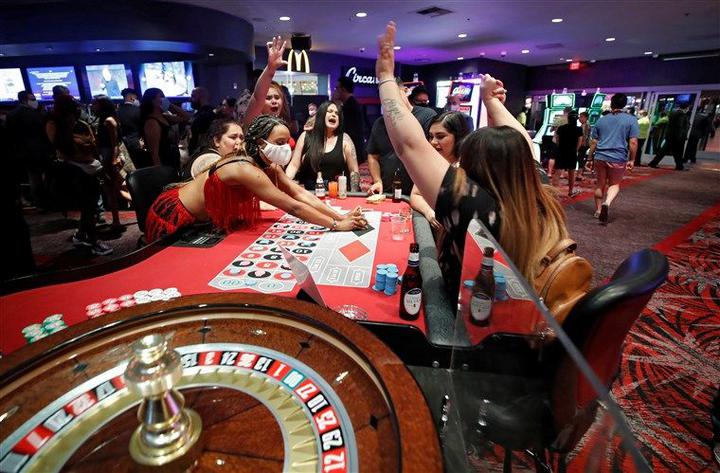许多游客在赌场不戴口罩,发牌员身处高风险环境中