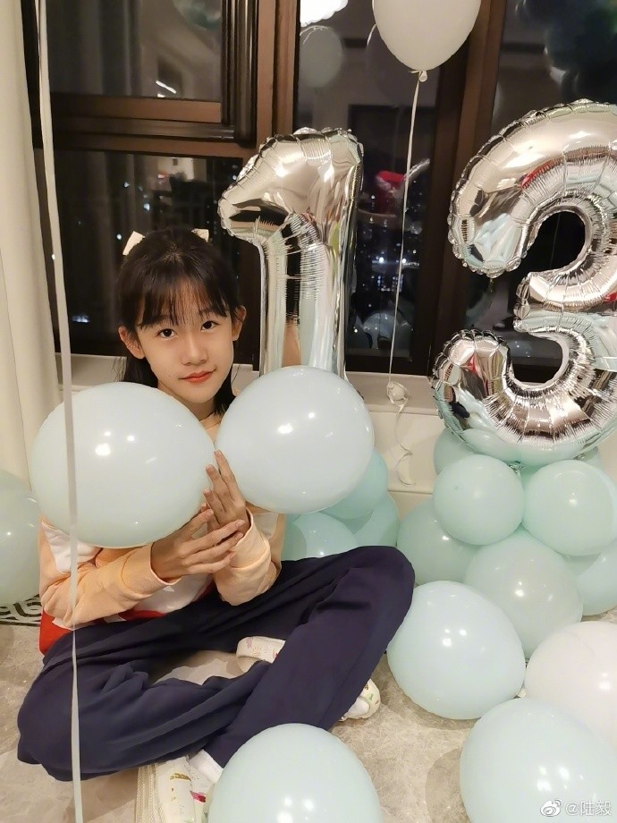 半扎马尾的贝儿蹲在地上享受着来自爸爸镜头的"宠爱",双手对镜比耶,好