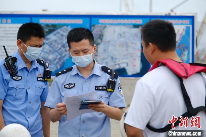 平潭边检站移民管理警察对船员证件进行查验。李宗艺 摄