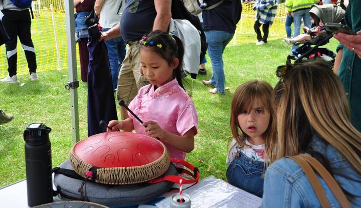 A group of children playing a drum

Description automatically generated