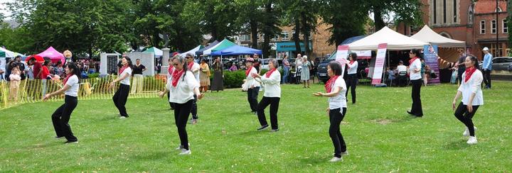 A group of people dancing in a park

Description automatically generated