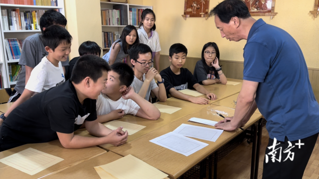 書法教師國政華正在給孩子們示范如何寫僑批。