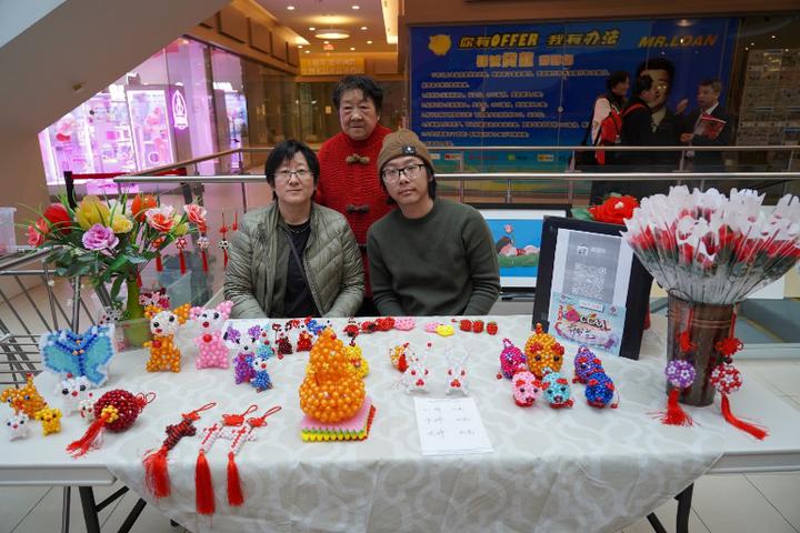 A group of people sitting at a table with a table covered in colorful decorationsDescription automatically generated