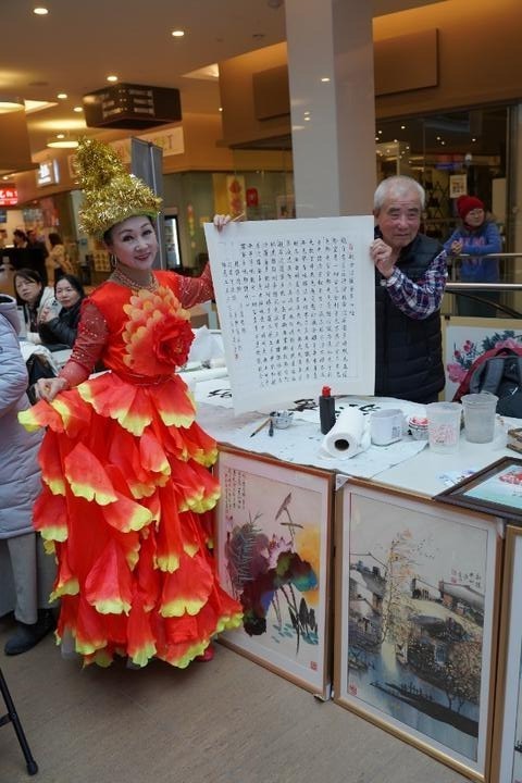 A person in a red dress holding a signDescription automatically generated