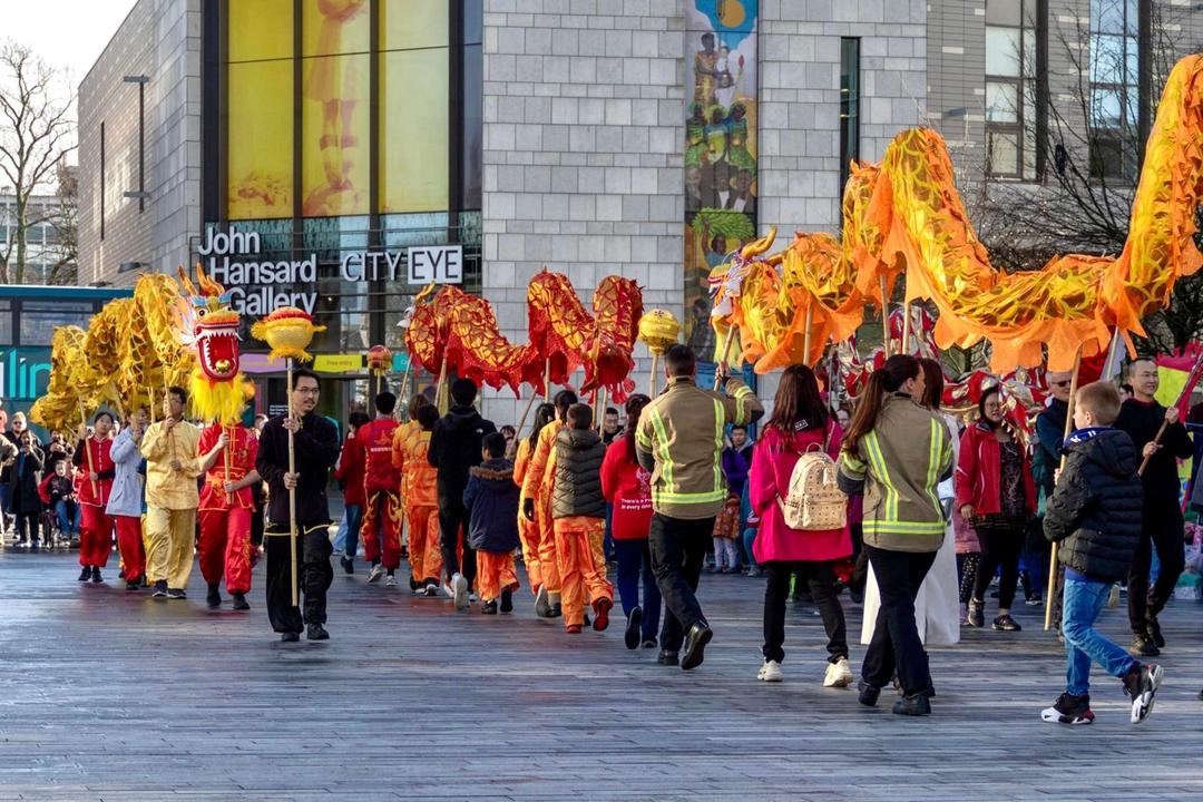 A group of people walking down a streetDescription automatically generated