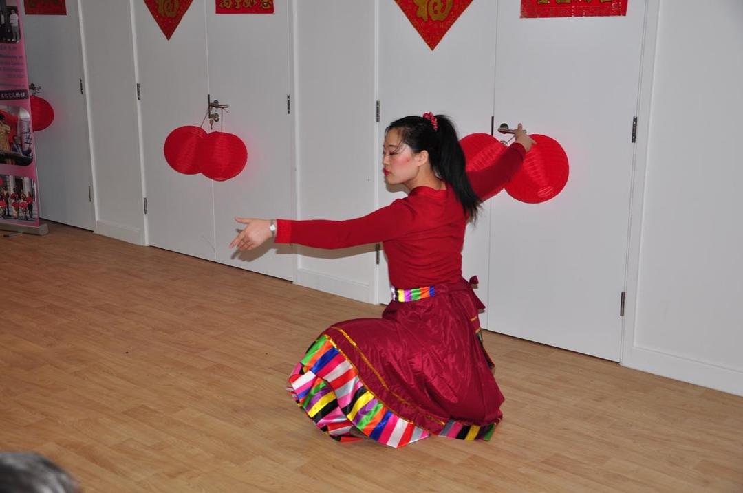 A person in a red dress kneeling on the floor

Description automatically generated