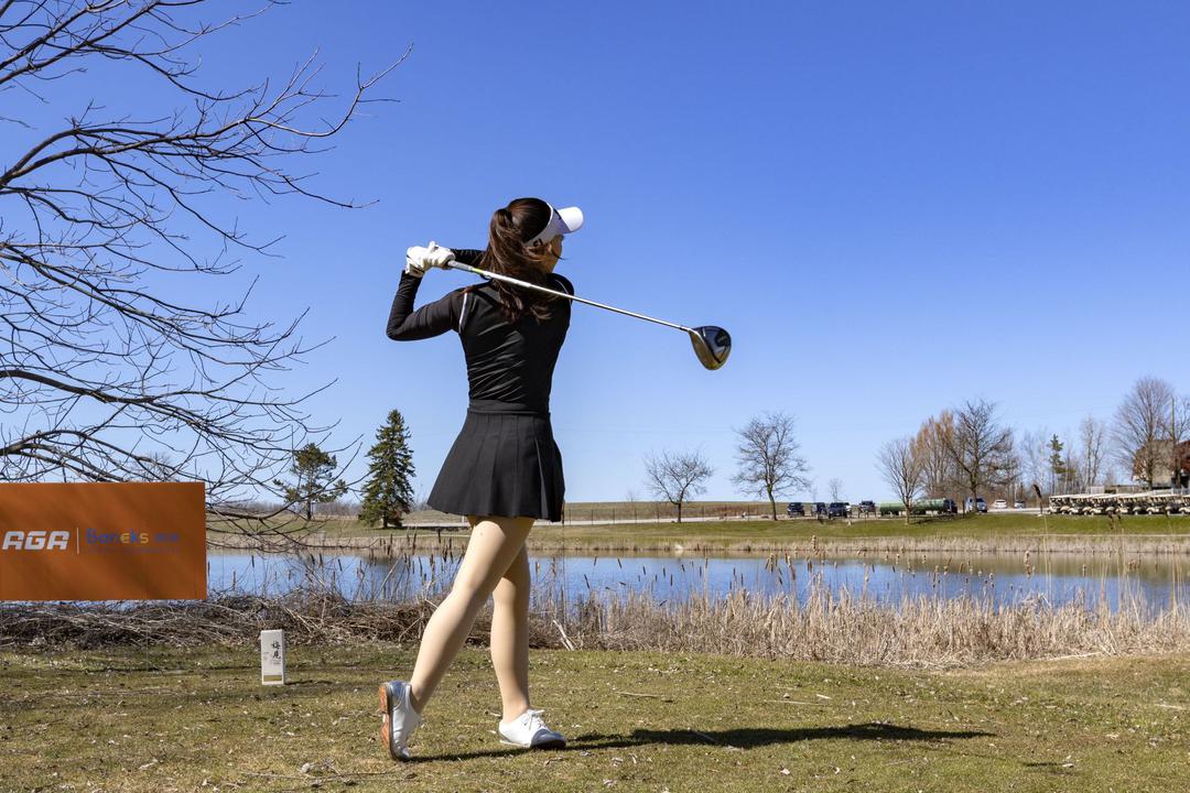 A person swinging a golf club

Description automatically generated
