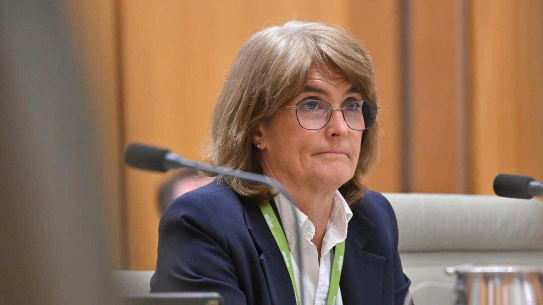 A woman wearing glasses and a suit