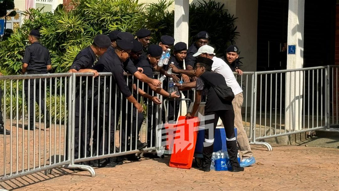 警方在大熱天下，監督「反安華集會」的安全和秩序，有民眾給警察送水解渴。