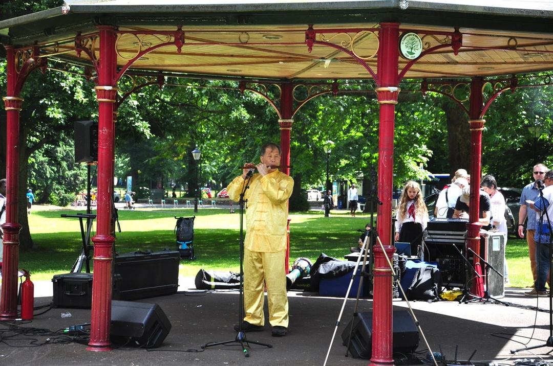 A person playing a flute under a gazebo

Description automatically generated