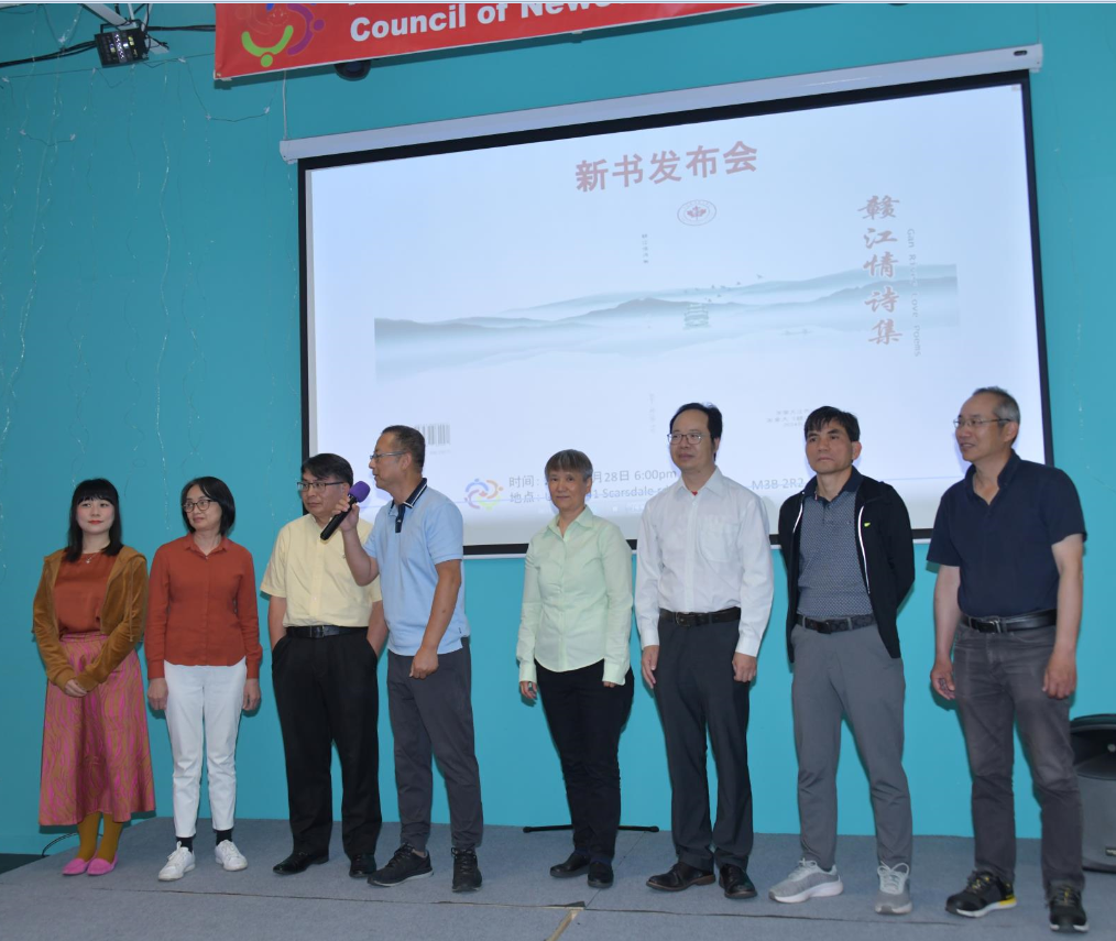 A group of people standing in front of a projector screen

Description automatically generated