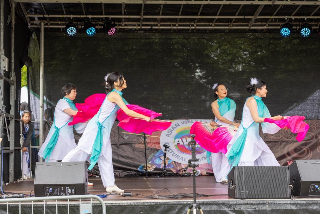 A group of women performing on a stage

Description automatically generated