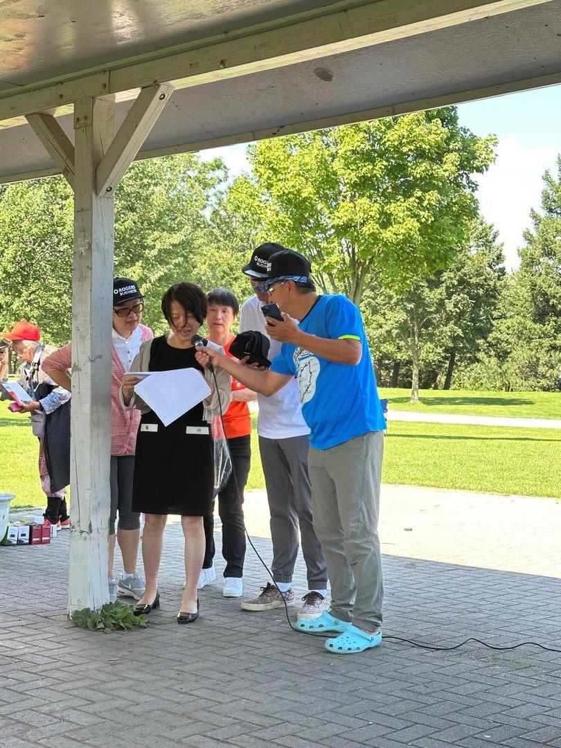 A group of people standing under a shelterDescription automatically generated