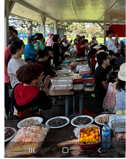 A group of people standing in a line at a food eventDescription automatically generated