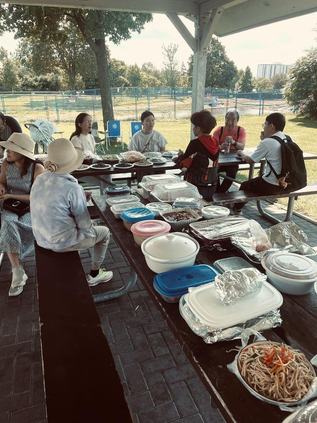 A group of people sitting at a picnic tableDescription automatically generated