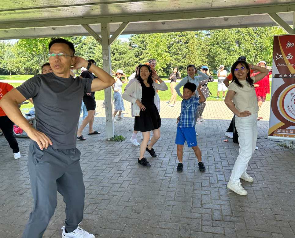 A group of people posing for a photo under a covered areaDescription automatically generated