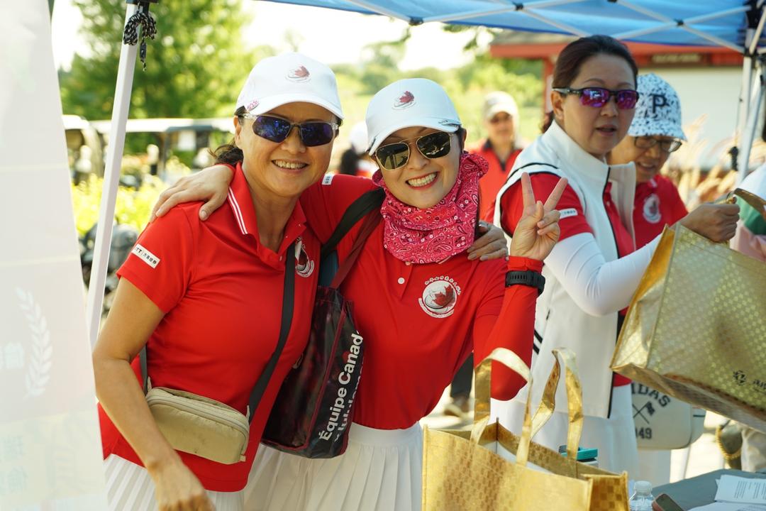 A group of women wearing white caps and red shirtsDescription automatically generated