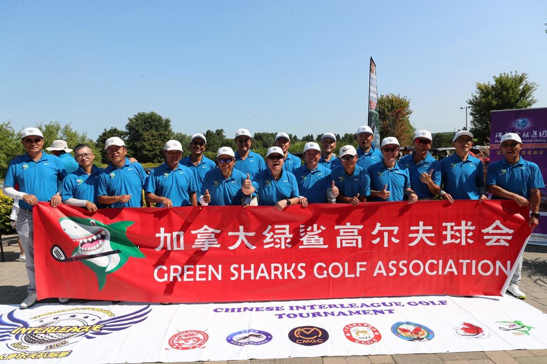 A group of men in blue shirts holding a bannerDescription automatically generated