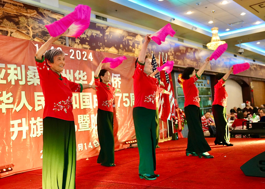 A group of women dancing on a red carpet

Description automatically generated