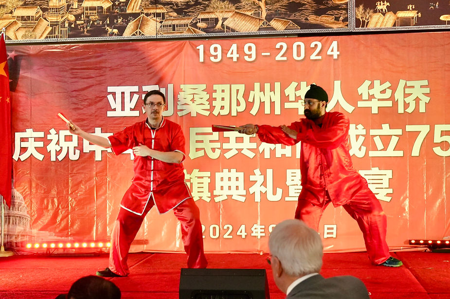 Two men in red uniforms on a stage

Description automatically generated