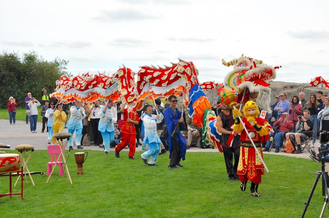 A group of people performing a dragon dance

Description automatically generated