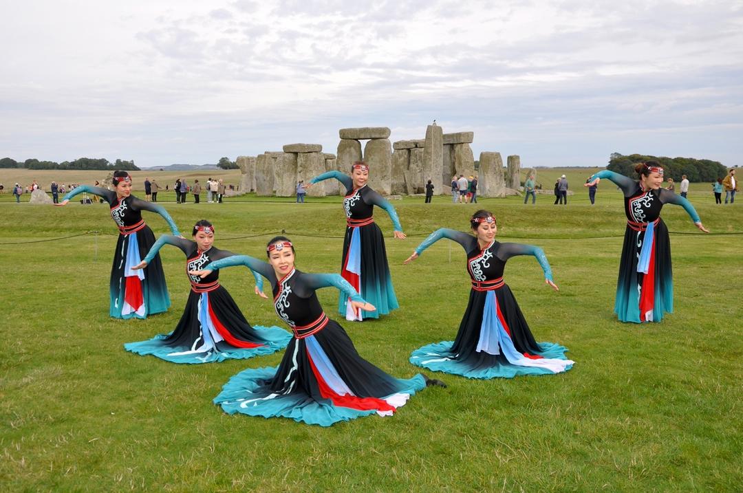 A group of women in clothing dancing in a field

Description automatically generated