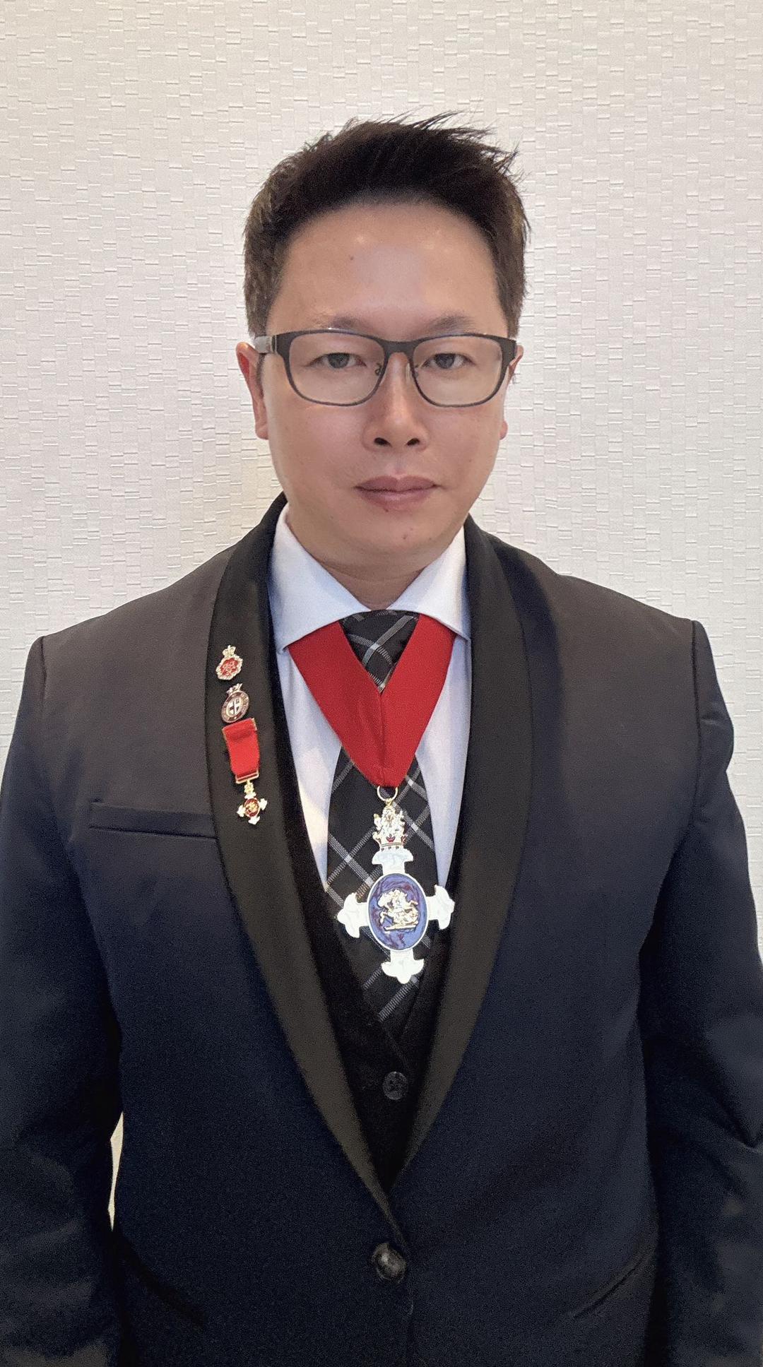 A person in a suit with medals

Description automatically generated