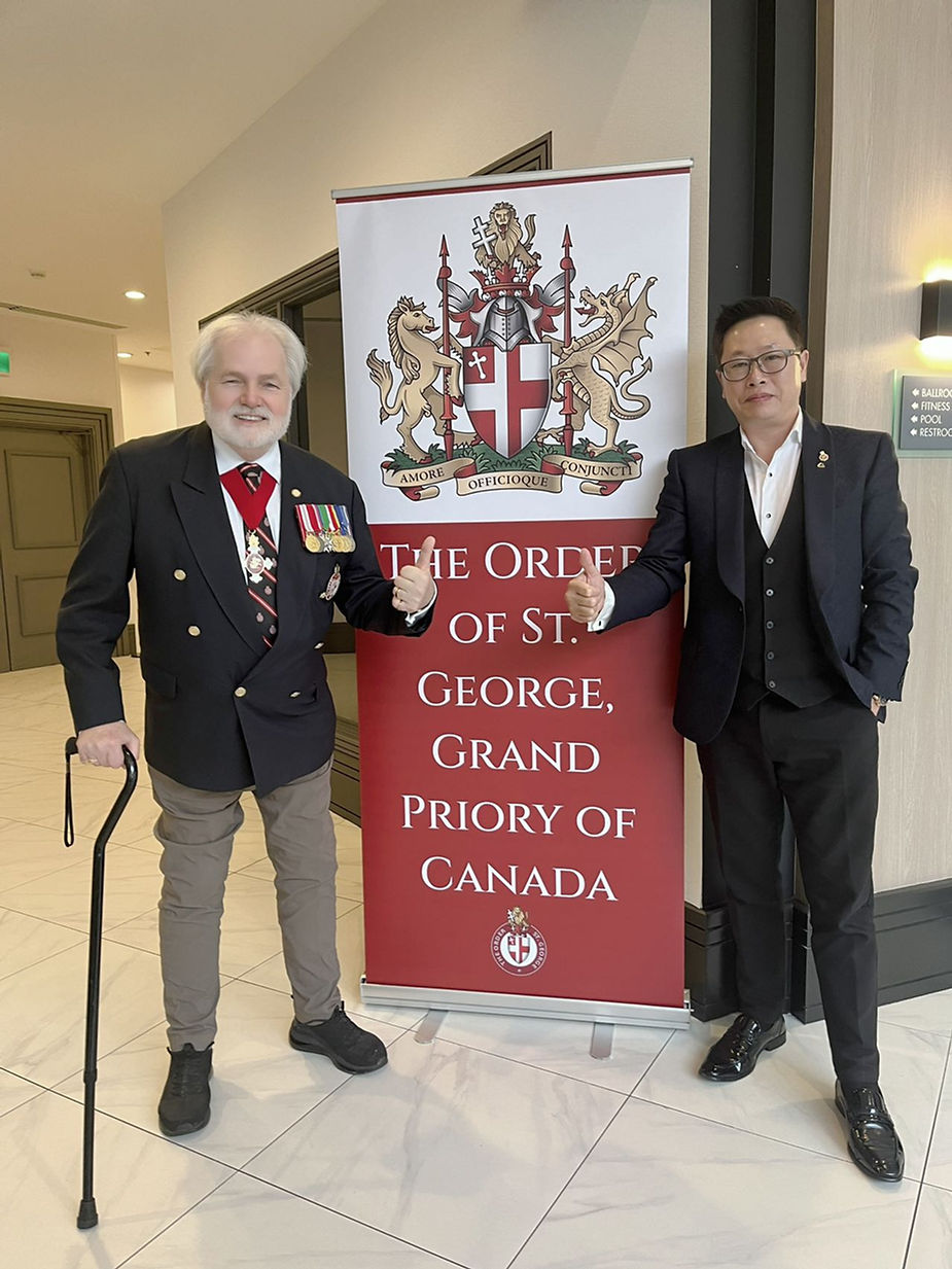 Two men standing in front of a sign

Description automatically generated