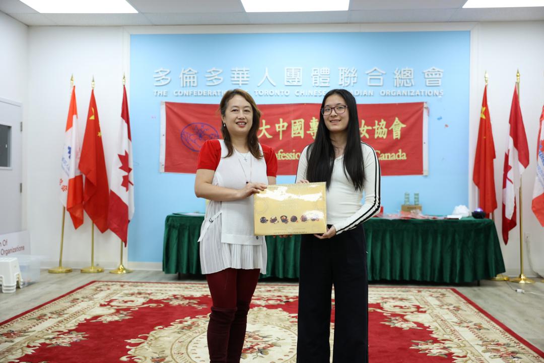 A couple of women holding a certificateDescription automatically generated