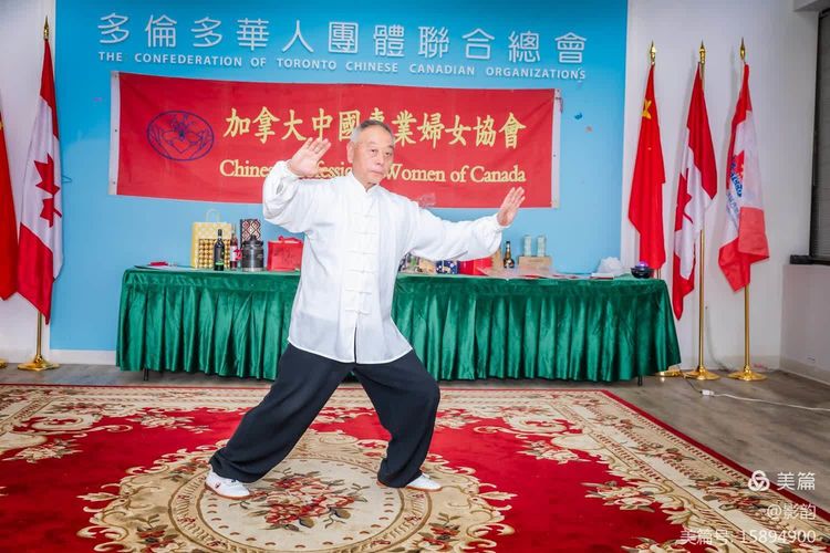 A person in a white shirt and black pants standing on a rug with his arms outDescription automatically generated