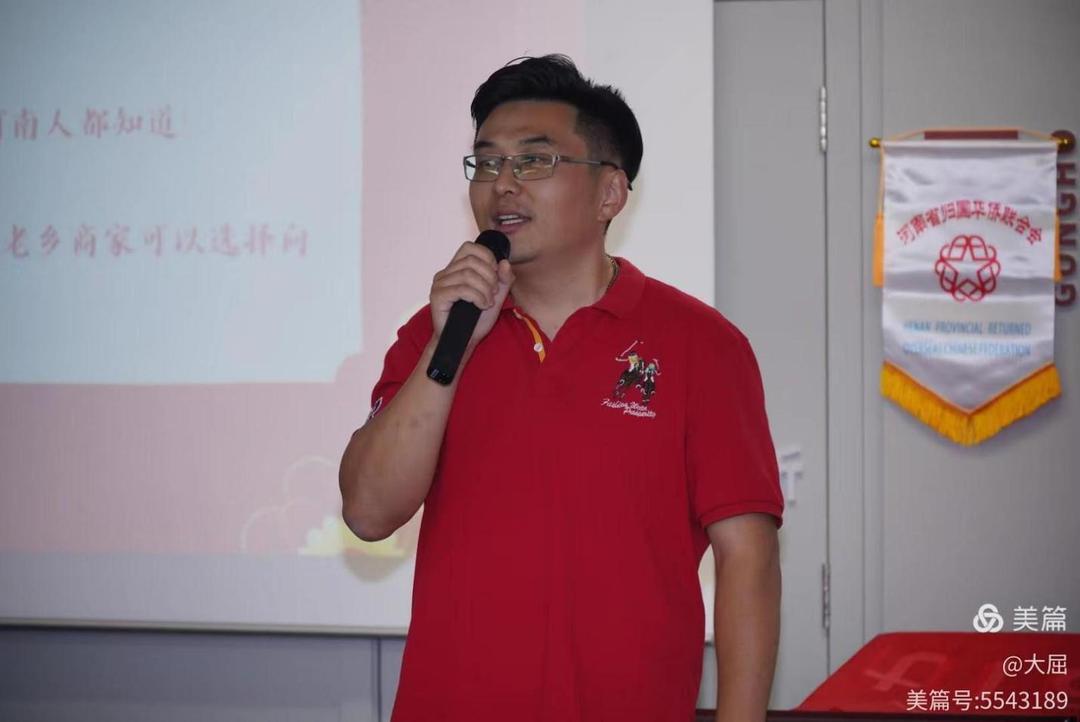 A person in a red shirt holding a microphone

Description automatically generated