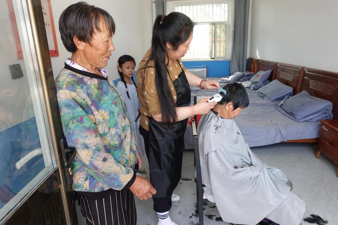 爱心人士余保霞为大保当镇东北湾村幸福院近百名老人义务理发