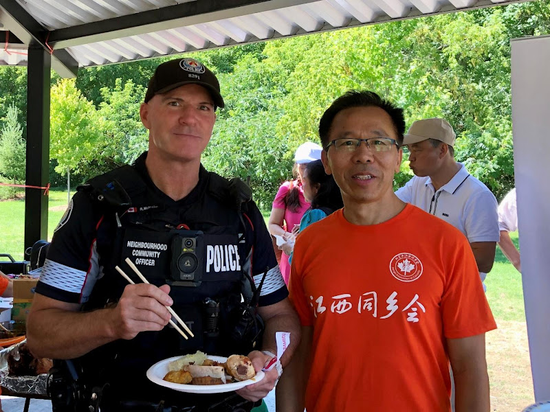 A person standing next to a police officer holding a plate of foodAI-generated content may be incorrect.