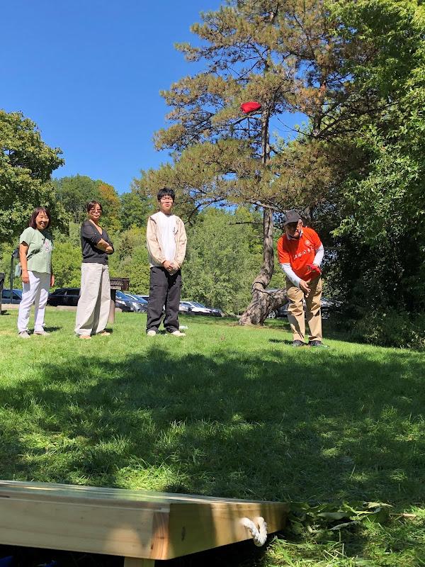 A group of people standing on grassAI-generated content may be incorrect.