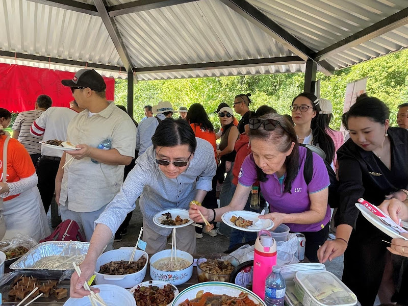 A group of people standing around a table with foodAI-generated content may be incorrect.