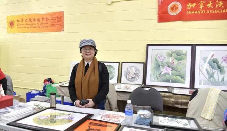 A person standing in front of a table with art AI-generated content may be incorrect.