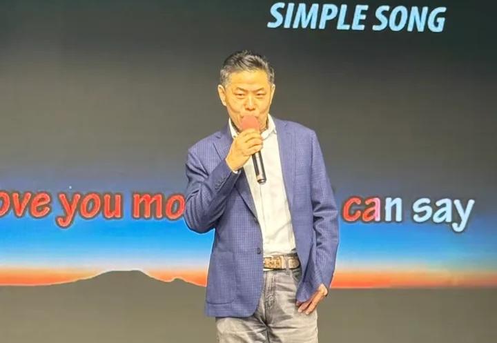 A person holding a microphone AI-generated content may be incorrect.