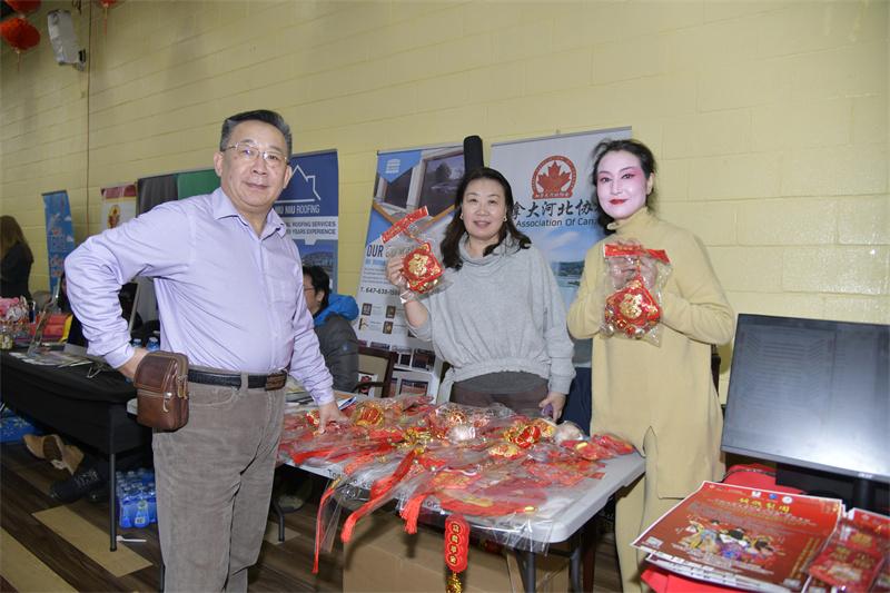 A group of people standing next to a table with red decorations AI-generated content may be incorrect.