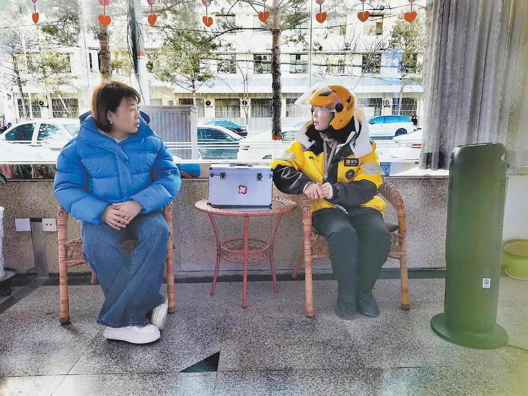 1月18日,在清涧县岔口路段的“红榆之家”里,外卖配送员王小峰(右)在取暖休息。邓聪摄