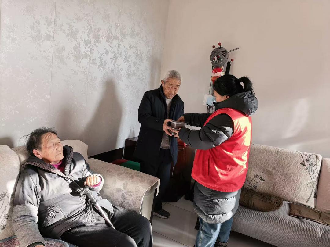 工作人员腊八粥递到每位居民手中