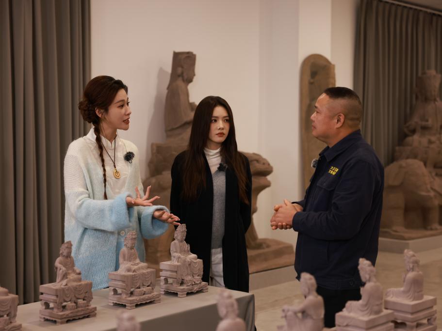 蔡文静和龚韵熹听大足石刻保安出身的工作人员讲述经历