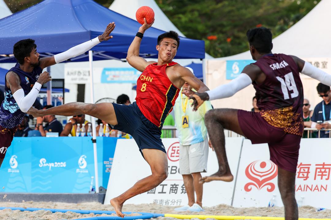 4月21日，在海南三亚举行的第六届亚洲沙滩运动会沙滩手球男子小组赛中，中国队2比0战胜斯里兰卡队。图为中国队球员马会锋（中）在比赛中进攻。（第六届亚洲沙滩运动会组委会供图）