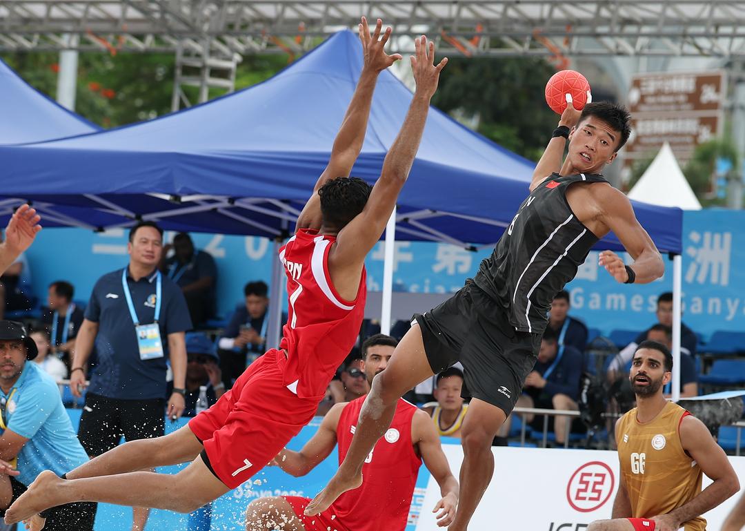 4月21日，在海南三亚举行的第六届亚洲沙滩运动会沙滩手球男子小组赛中，中国队0比2不敌巴林队。图为中国队球员马会锋（上右）在比赛中射门。（第六届亚洲沙滩运动会组委会供图）