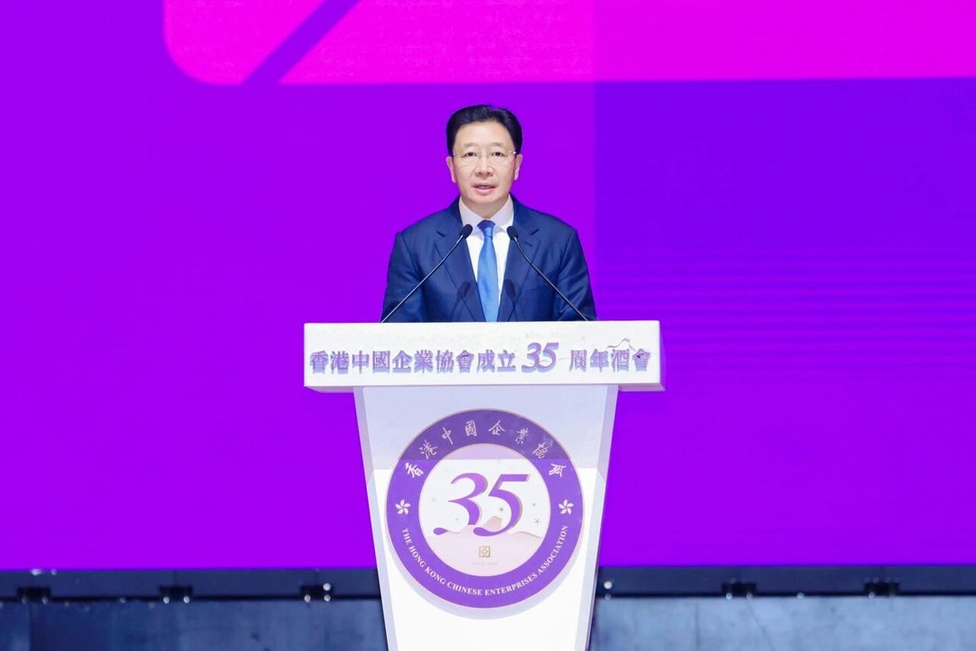講台上演講者的一般活動照,講台橫額和徽章標示活動名稱,但圖片本身資訊不多。(35/100) 講台上演講者的一般活動照,講台橫額和徽章標示活動名稱,但圖片本身資訊不多。